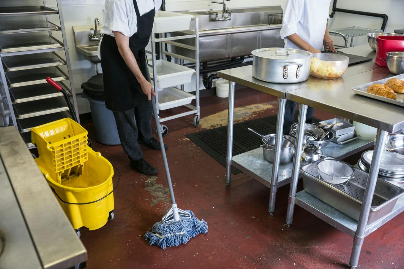 pracownik kuchni myje podłogę